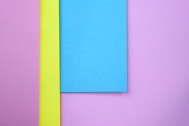 Geometrik şekilli arka plan. Mavi, pembe ve sarı kağıtlardan oluşan soyut bir arka plan. Üst görünümü farklı renklerde kalın kağıt. Soyut kağıt renkli arkaplan, yaratıcı tasarım 