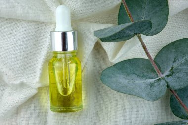 Cam şişede yağlı, üstten pipetli. Kütikül yağı yakın plan. Deri ve saç bakım ürünleri. Sarı sıvılı şeffaf bir şişe. Sağlık ve güzellik kavramı.