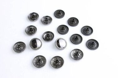 Beyaz arka planda düz şekilli kıyafetler için siyah şapka düğmeleri. Çantalar ve dış giyim için metal dekoratif düğme. Giysiler ve aksesuarlar için aksesuarlar dikiyorum. perçinler 
