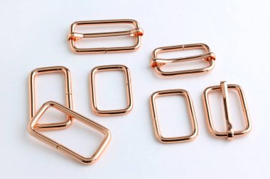 Belt adjuster frames, color red gold. Metal frame with a movable part for changing the length of the strap on the bag. Accessories for sewing backpacks and bags.  clipart