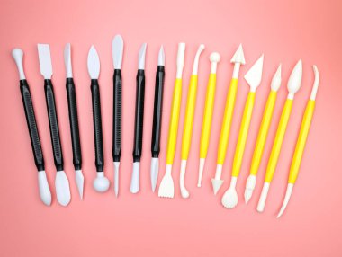 Sanat ve el işi heykel aletleri. Pembe arka plandaki plastikler için plastik desteler. Hobi unsurları. Heykel aletleri üst görünüm. Modern çömlek aletleri seti. Sanat stüdyosu ekipmanı. 