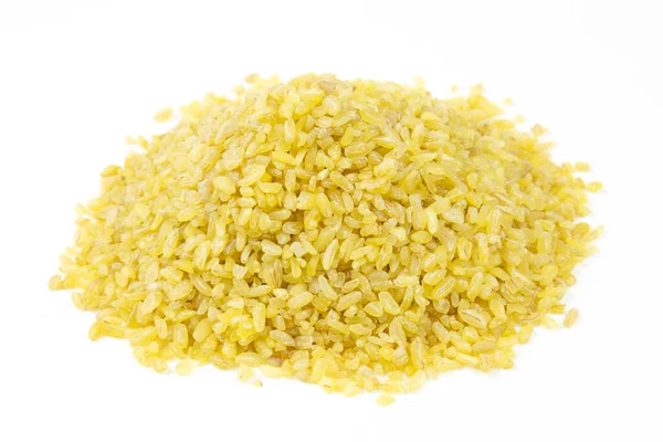 Beyaz arka planda çiğ bulguru yığını. Kuru bulgur yığını. Yakın çekim..