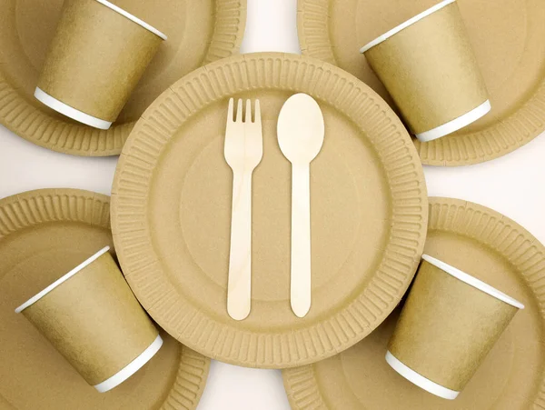 Tahta kahverengi çatallar, kaşıklar, tek kullanımlık kağıt bardaklar. Sıfır atık, çevre dostu, karton, kağıt masa takımı. Sokak yiyecekleri ambalaj kupaları, tabaklar kapanıyor..