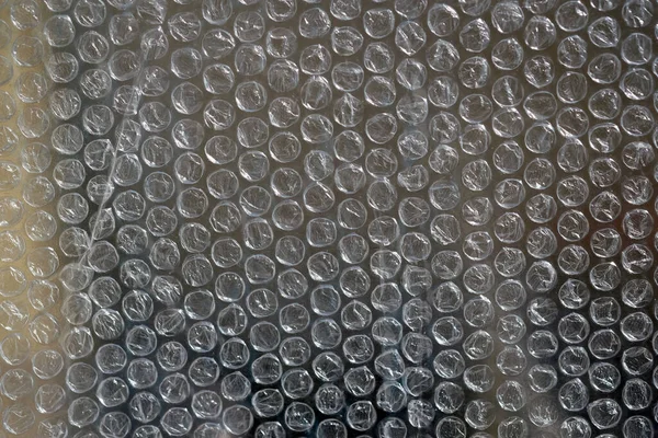 Air bubble wrap close-up. Bubble wrap texture. Texture background packaging material. The film protects the surface from impact. Polyethylene.