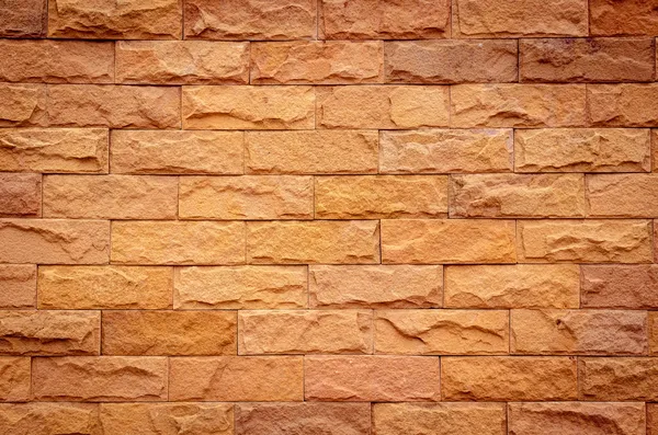 Una pared de ladrillo en diferentes tonos naranjas naturales —  Fotos de Stock