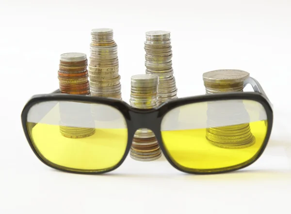 Stakes of coins and old style sunglasses — Stock Photo, Image