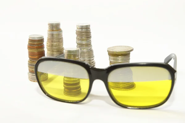 Stakes of coins and old style sunglasses — Stock Photo, Image