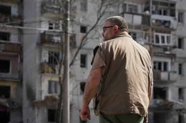 Bir adam, bombanın çarptığı yıkık bir eve bakıyor.