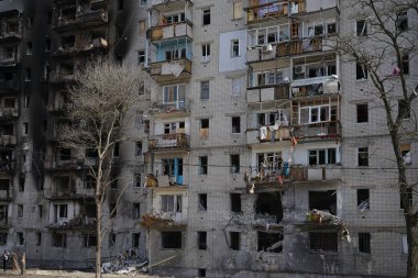 Ukrayna 'daki savaşta patlayan bir bombadan dolayı kırık camlı binanın ön cephesi. Kırık camlarda rüzgarda sallanan perdeler