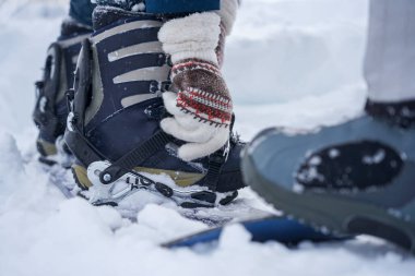 Kar kaykayı bağlayan kız