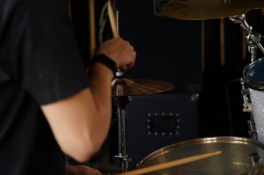 Stüdyoda yüksek şapkalı ve zilli yakın çekim. Davul takımı