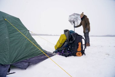 Adam kışın dışarıda çekim yapmak için kamera arkası flaşını ayarlıyor.