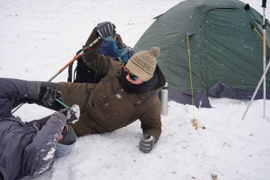 Çocuklar çadırın yanındaki telefonda birbirlerinin fotoğraflarını çekiyorlar.