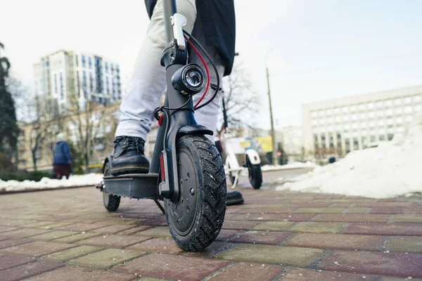 Elektrikli scooter yakın plan. Adam parkta elektrikli scooter 'ın yanında duruyor. İlkbahar parkında güzel bir scooter fotoğrafı.