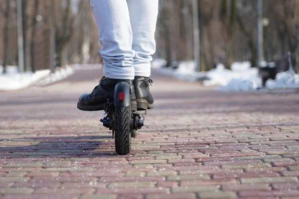 Adam parkta elektrikli scooter kullanıyor.