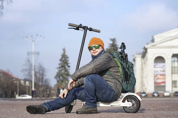 Guy Photographer Sits Electric Scooter Spring Park Wearing Warm Jacket — Fotografia de Stock