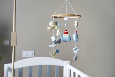 Diy craft baby crib mobile. Toys hang over the crib