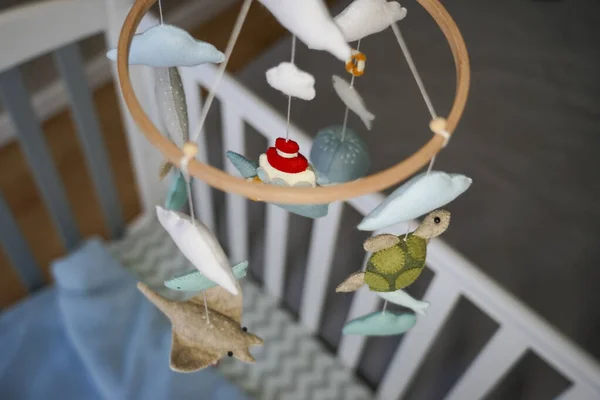 Diy craft baby crib mobile. Toys hang over the crib