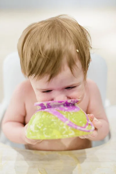 笑顔面白いです赤ちゃん女の子食べる食べ物とともに手 — ストック写真