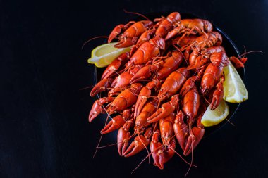 Koyu ahşap masada limonlu taze kırmızı kerevit.