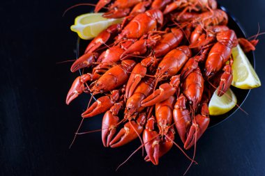 Koyu ahşap masada limonlu taze kırmızı kerevit.