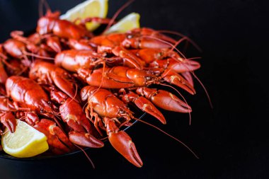 Koyu ahşap masada limonlu taze kırmızı kerevit.