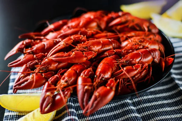 Koyu ahşap masada limonlu taze kırmızı kerevit.