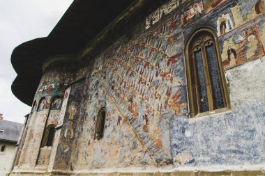Sucevita, Romanya - 17 Ağustos 2014: Sucevita, Romanya 'daki güçlendirilmiş manastırı, Eski ve Yeni Ahit, unesco mirasından İncil bölümlerini resmeden büyük sanatsal değerlere sahip dış duvar resimleriyle benzersiz bir şekilde resmetmiştir.