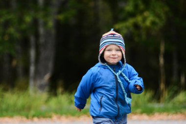 Mavi gözlü neşeli çocuk yüzünü buruşturuyor.