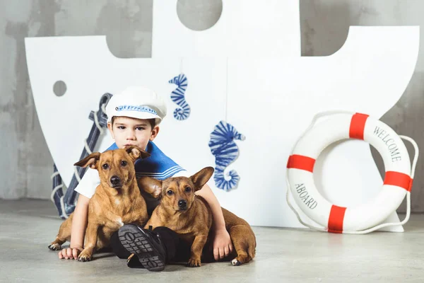 Cabine menino com dois cães pequenos na frente do navio — Fotografia de Stock
