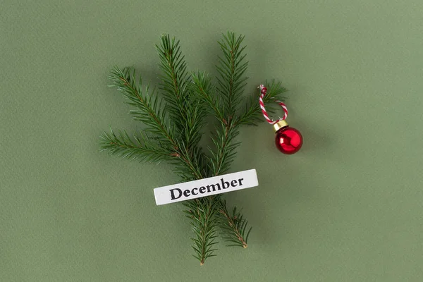 Calendar winter month December and christmas tree on green background. Top view Flat lay. Minimal Holiday concept. Template for your design, greeting card.