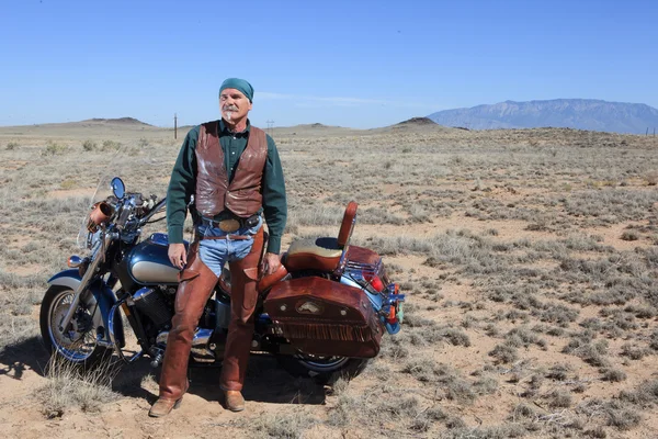 Robusto pensionato con la sua moto nel sud-ovest . Fotografia Stock