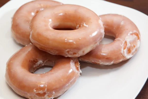 Glazed donuts on white plate Stock Image