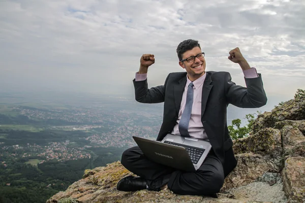 Gelukkig zakenman met laptop in aard succes concept Stockfoto