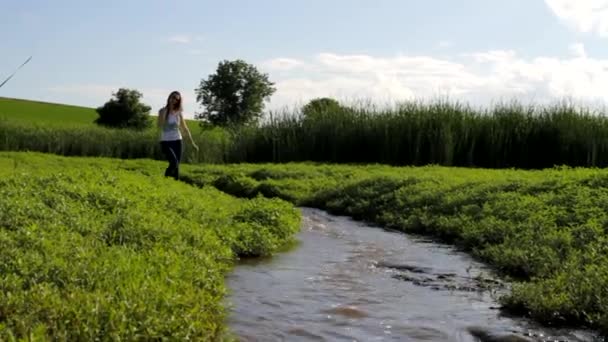 Жінка в джинсах ходить по воді — стокове відео