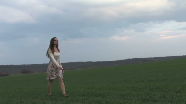 Jonge vrouw lopen op lente gras — Stockvideo