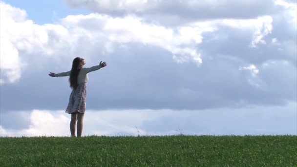 Mulher com as mãos estendidas em um campo de primavera — Vídeo de Stock