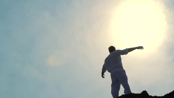 Aanbidding pose silhouet man bergtop verhogen armen zon — Stockvideo