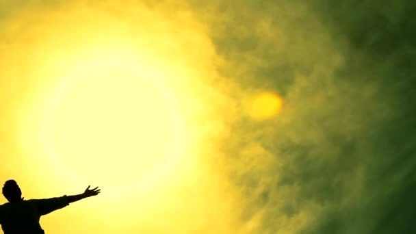Ciel coloré avec l'homme dans un Christ comme la pose regardant la casserole de soleil — Video