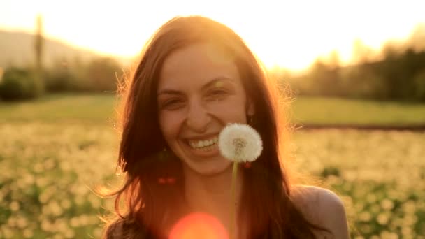 Mooi meisje model blazen paardebloem lachen zomer veld — Stockvideo