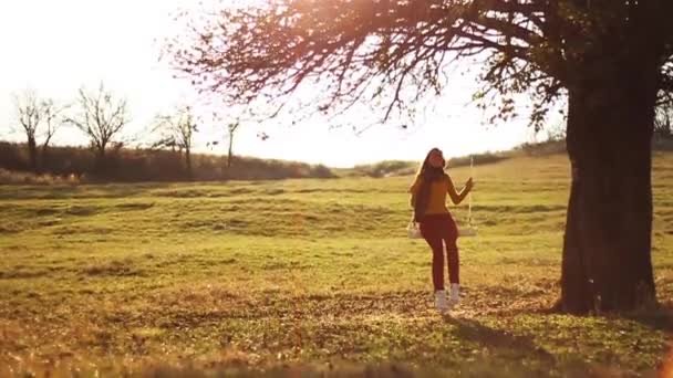 Vrouw op boom schommel — Stockvideo