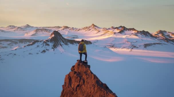 Vzduch kolem mladého turisty Muž stojící na vrcholu hory Summit při západu slunce Expedice Výzva Dron Epická Nepřízeň Dobytí strachu úzkost koncepce — Stock video