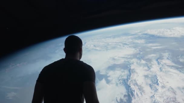 Silueta de un hombre frente a la Tierra en la Nave Espacial Vista Global Gran Reinicio Conspiración Cambio Climático Espacio Viajando Verde Tierra Medio Ambiente Rojo Épica 8k — Vídeo de stock