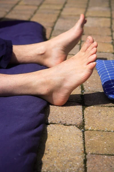 Pies y una esterilla de yoga — Foto de Stock