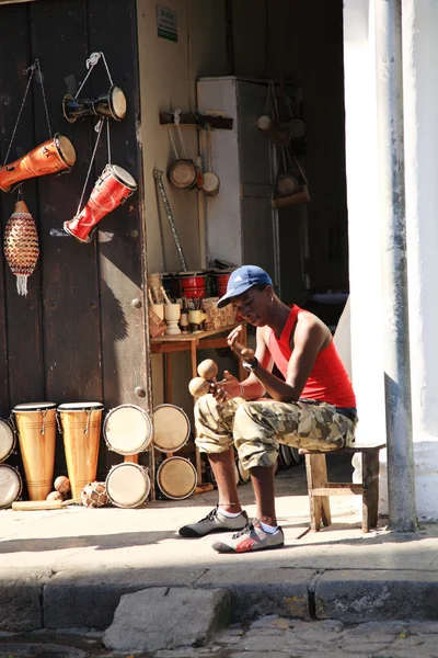 Hombre sentado fuera de la tienda de instrumentos musicales — Foto de Stock