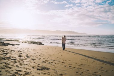 Anne ve küçük çocuğu kumsalda oynuyorlar ve birlikte eğleniyorlar. Dışarıda mutlu bir aile. Anne ve bebek yazın doğada. Olumlu insani duygular ve duygular. Deniz kıyısında aile tatili.