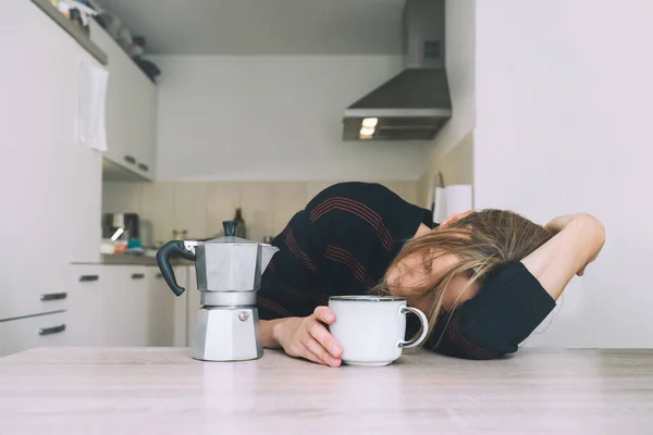 Tired sleepy person female having some problems. Exhausted woman with coffee at home. Concept of woman or mother in depression, burnt out, tired from work or study, unsatisfactory with her life.