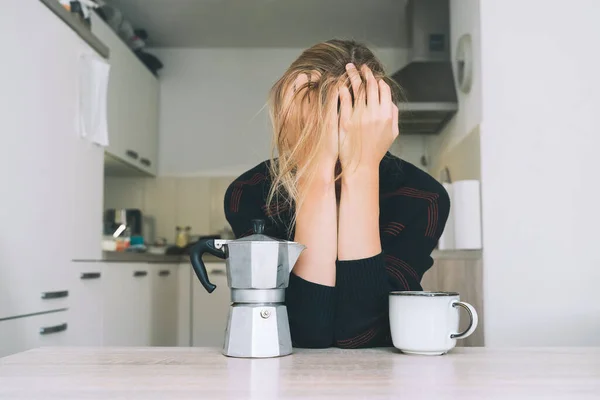 Tired sleepy person female having some problems. Exhausted woman with coffee at home. Concept of woman or mother in depression, burnt out, tired from work or study, unsatisfactory with her life.