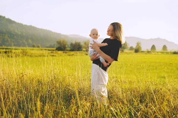 Anne ve bebek. Doğal annelik ve annelik kavramı. Güzel kadın ve küçük bebek yeşil doğada birlikte mutlular. Dışarıda çocuklu bir anne..