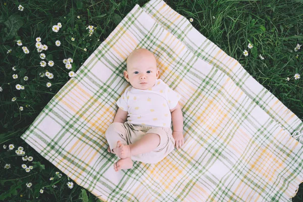 夏の屋外で緑の芝生の上に毛布に寝そべってかわいい幸せな赤ちゃん 自然の中で3ヶ月裸足の赤ちゃん エコ持続可能なライフスタイルの家族と子供時代の概念 — ストック写真